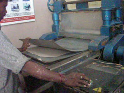 Paper Recycling: sheets of paper being pressed in a Calendering Machine