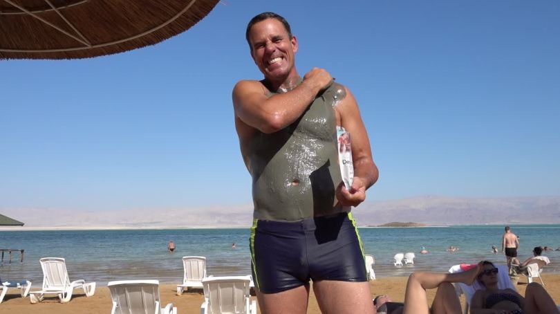 Man with mud in the Dead Sea